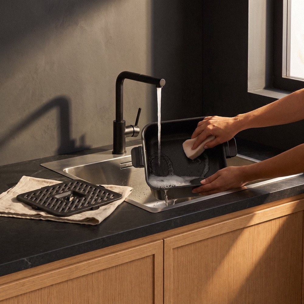 The square 8 L pot washed under running water, crisper plate drying on a towel